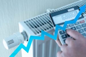 UK homeowner checking central heating cost per hour in 2025 on a calculator